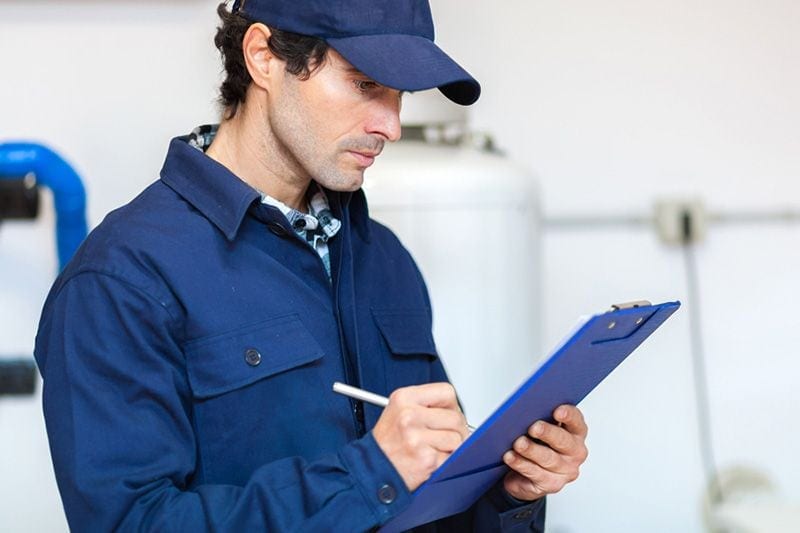 A technician studies a clipboard.